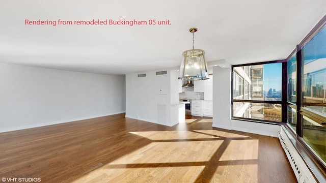 unfurnished dining area with baseboards, a baseboard radiator, wood finished floors, and visible vents