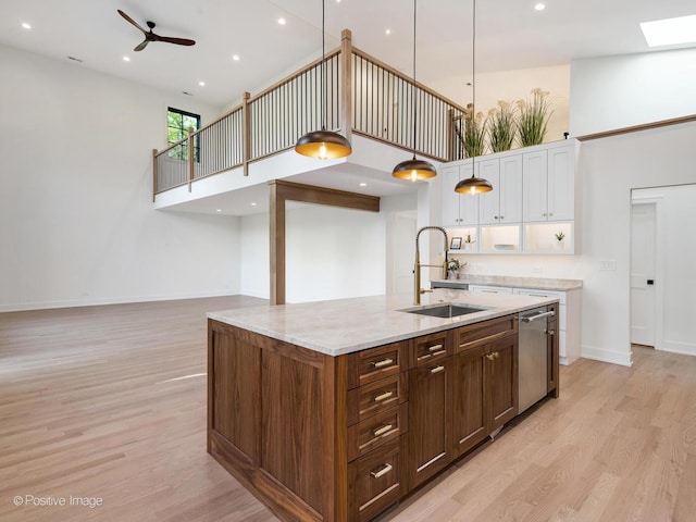 118 Lockerbie Ln, Wilmette, IL 60091 - kitchen with a sink, a towering ceiling, white cabinetry, light wood-type flooring, and a skylight