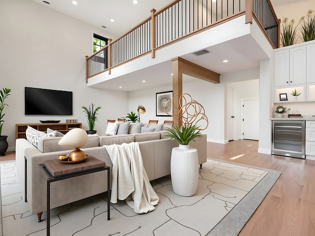 118 Lockerbie Ln, Wilmette, IL 60091 - living area with beverage cooler, a high ceiling, light wood-style floors, bar, and recessed lighting