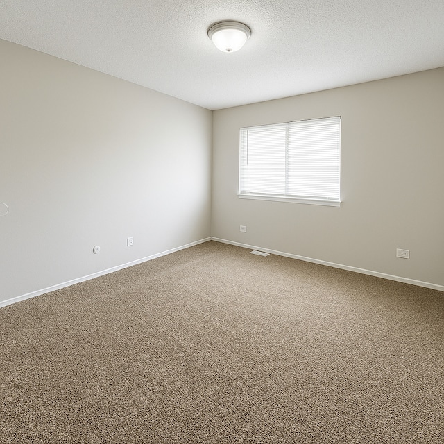 carpeted spare room featuring visible vents, a textured ceiling, and baseboards
