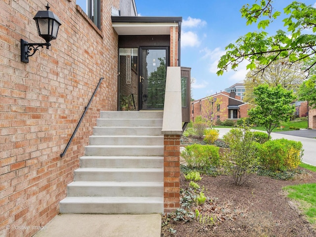 view of exterior entry featuring brick siding