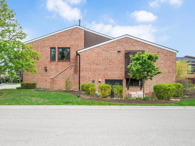 view of side of property featuring a yard and brick siding
