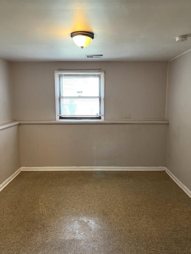 spare room with baseboards and visible vents