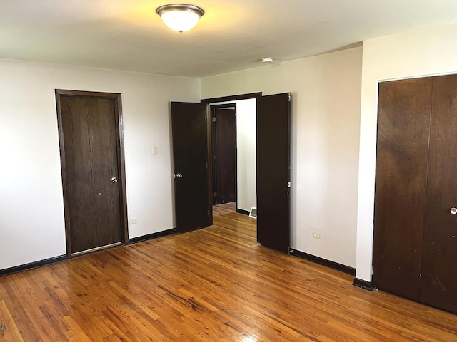unfurnished bedroom featuring baseboards and wood finished floors