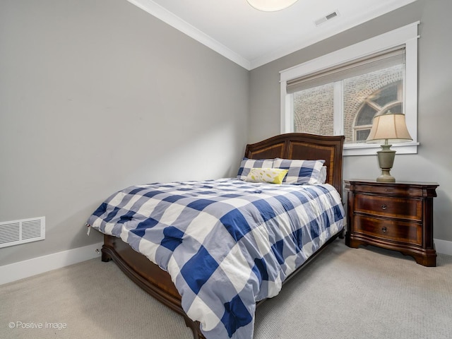 carpeted bedroom with ornamental molding and baseboards