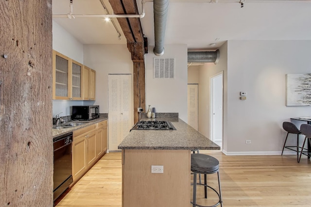 1735 W Diversey Pkwy Unit 206, Chicago, IL 60614 - kitchen with black appliances, track lighting, a kitchen bar, and light brown cabinetry