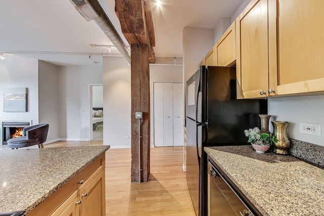 1735 W Diversey Pkwy Unit 206, Chicago, IL 60614 - kitchen with light wood-type flooring, light brown cabinetry, light stone counters, open floor plan, and a lit fireplace