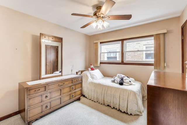 bedroom featuring light colored carpet and a ceiling fan