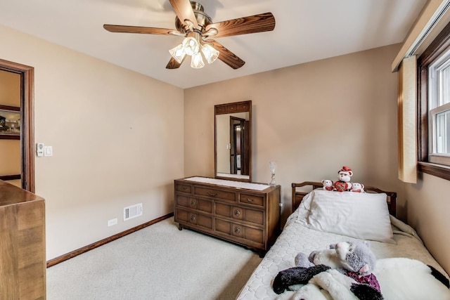 carpeted bedroom featuring baseboards, ceiling fan, and visible vents