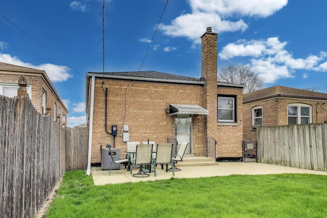 rear view of house with a chimney, a lawn, central AC unit, a patio area, and a fenced backyard