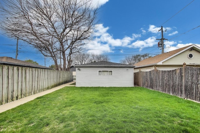 view of yard with a fenced backyard and an outbuilding