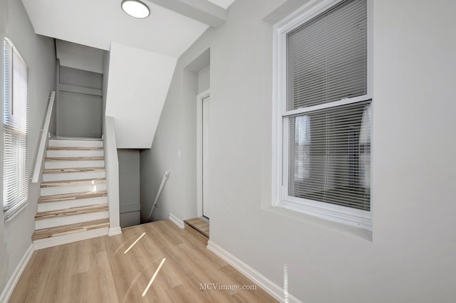 staircase with baseboards and wood finished floors