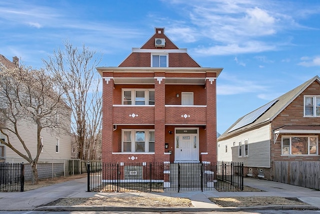 view of front facade with brick siding, a fenced front yard, and a gate