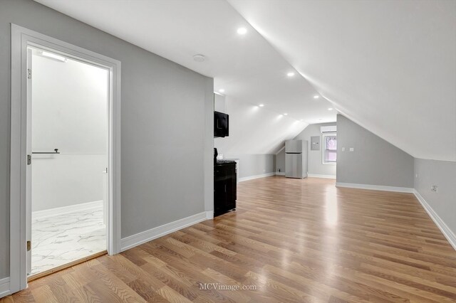 bonus room featuring light wood-style floors, baseboards, recessed lighting, and lofted ceiling