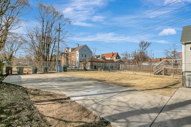 exterior space featuring stairs, a residential view, and concrete driveway