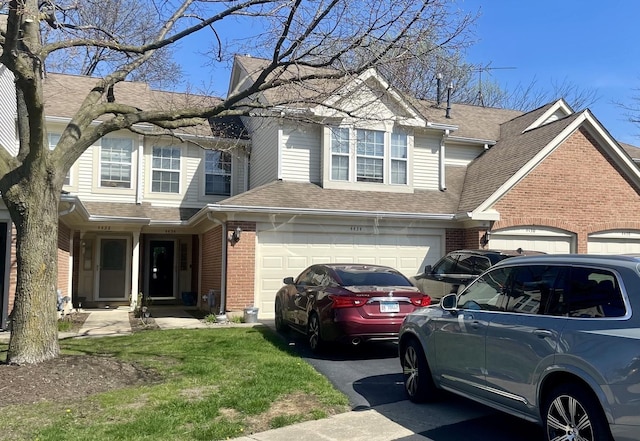 4434 Edinburg Ln Unit 0, Hanover Park, IL 60133 - view of front of property with brick siding, an attached garage, aphalt driveway, and roof with shingles