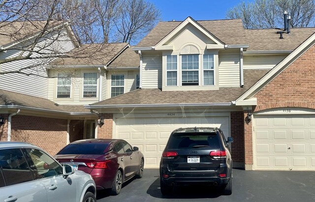 4434 Edinburg Ln Unit 0, Hanover Park, IL 60133 - view of front facade featuring brick siding, driveway, and a shingled roof