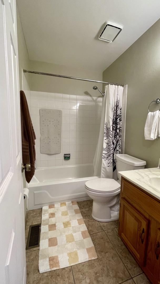 4434 Edinburg Ln Unit 0, Hanover Park, IL 60133 - bathroom with vanity, toilet, tile patterned floors, shower / bathtub combination with curtain, and visible vents