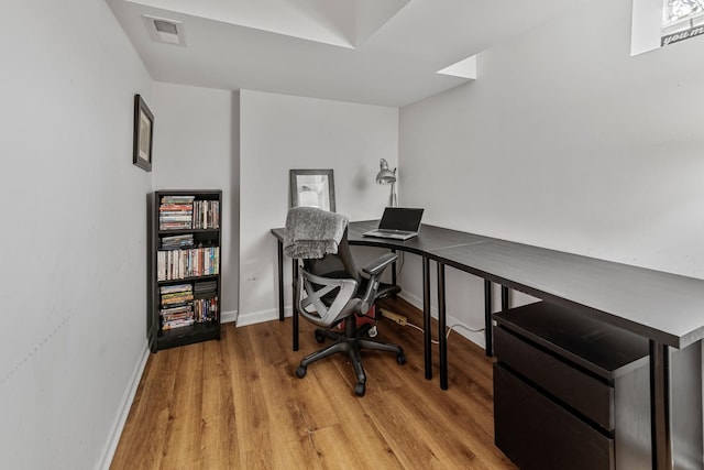 office area featuring baseboards, visible vents, and light wood-style flooring