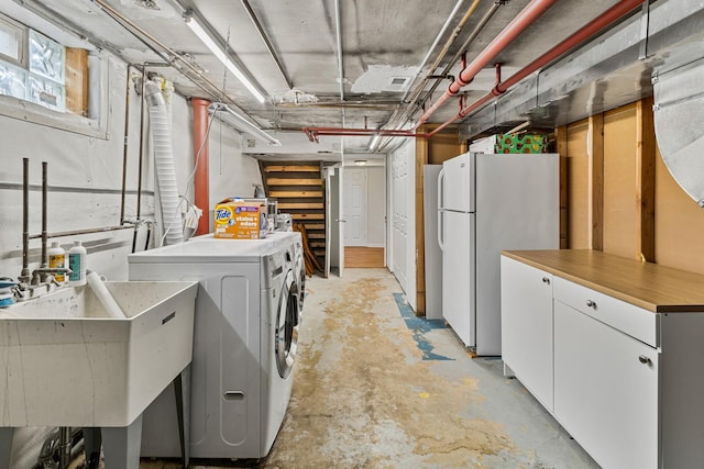 washroom with visible vents, a sink, cabinet space, and washing machine and clothes dryer