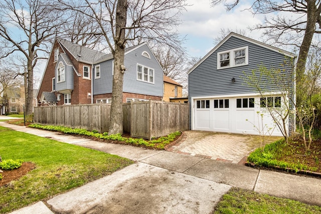 view of side of property with fence and decorative driveway