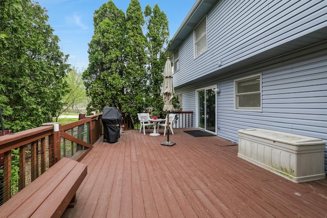 wooden deck with outdoor dining area and area for grilling