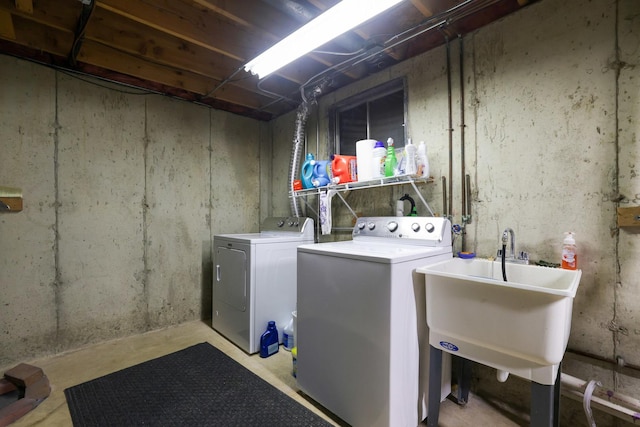 clothes washing area with a sink, laundry area, and washing machine and clothes dryer