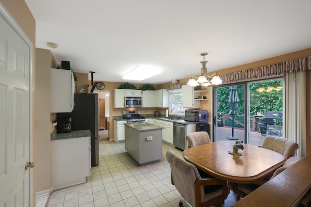 281 Windsor Dr, Bartlett, IL 60103 - kitchen with a notable chandelier, stainless steel appliances, white cabinetry, light tile patterned floors, and a kitchen island