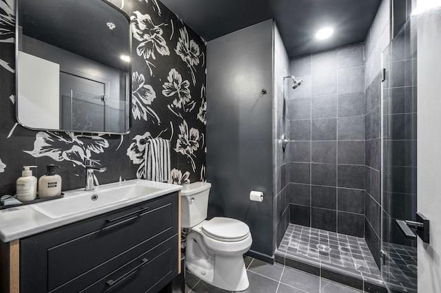 full bath with tile patterned flooring, a tile shower, vanity, toilet, and wallpapered walls