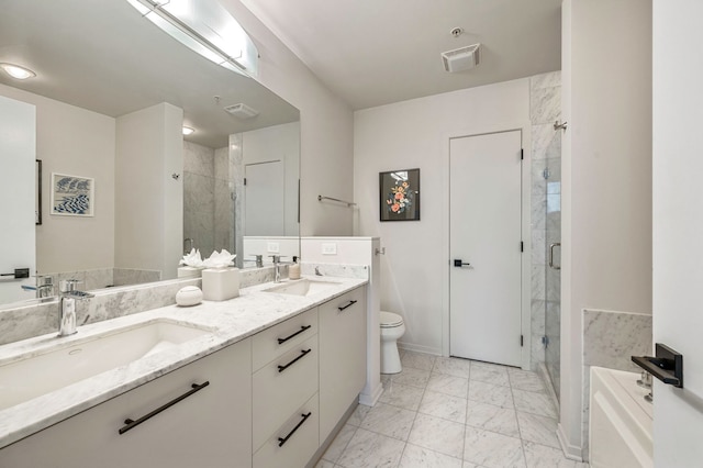 full bathroom with double vanity, marble finish floor, toilet, a shower stall, and a sink