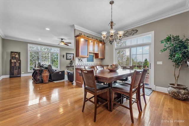 dining room featuring crown molding, baseboards, and light wood-style flooring