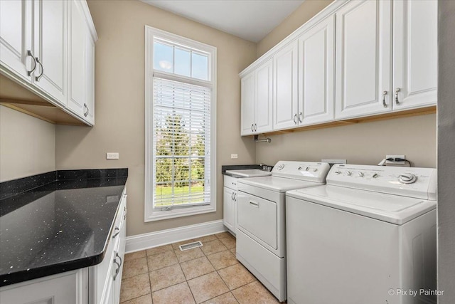 laundry room featuring visible vents, washing machine and dryer, light tile patterned flooring, baseboards, and cabinet space