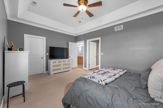 bedroom featuring a raised ceiling, a ceiling fan, light colored carpet, and visible vents