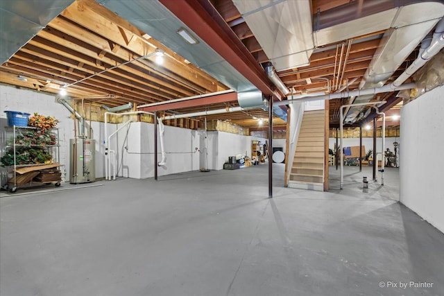 unfinished basement with water heater and stairway