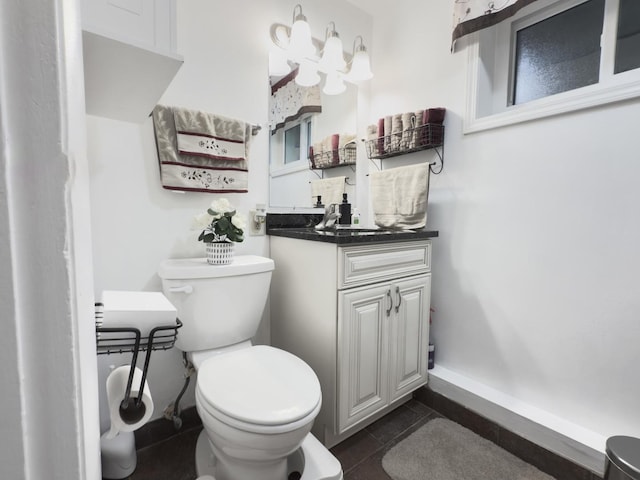 bathroom with vanity, tile patterned flooring, baseboards, and toilet