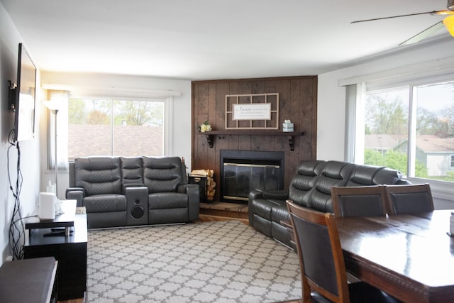living room with ceiling fan and a large fireplace