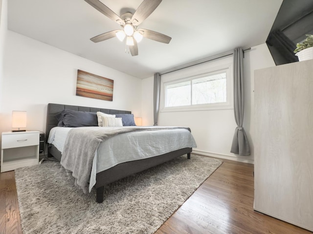 bedroom featuring baseboards, a ceiling fan, and wood finished floors
