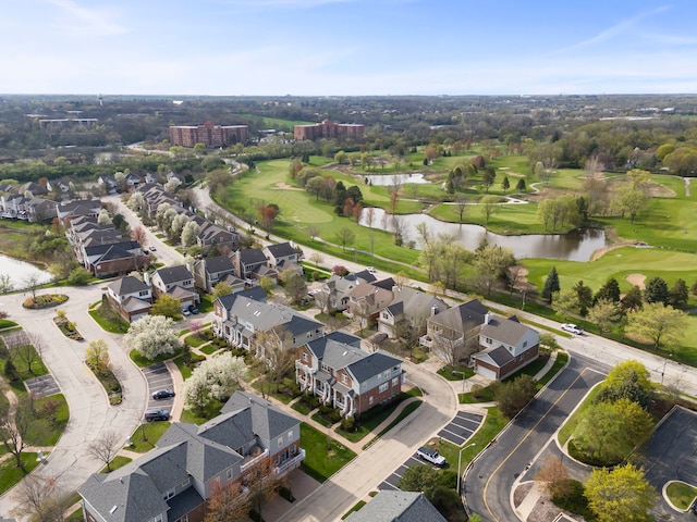 drone / aerial view featuring a water view, view of golf course, and a residential view