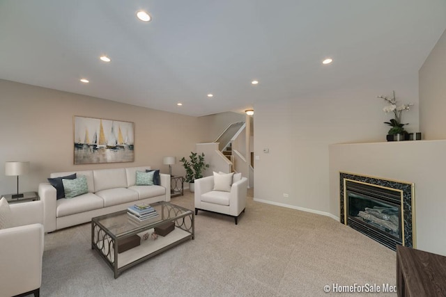 carpeted living area with stairway, baseboards, a fireplace, and recessed lighting