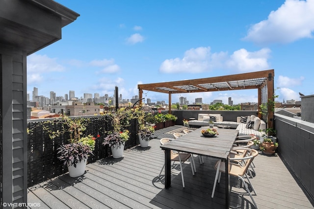 wooden deck featuring a pergola, a city view, and outdoor dining space