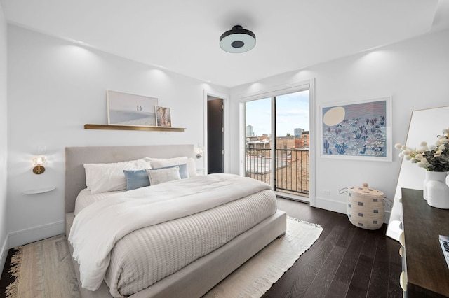 bedroom featuring baseboards, access to exterior, and wood finished floors