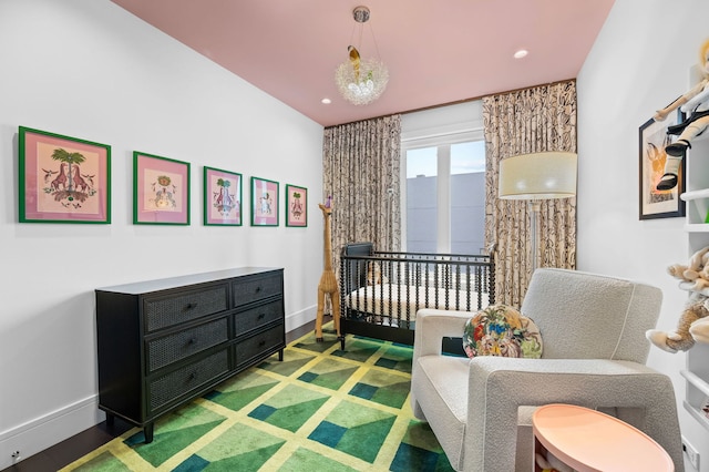 bedroom with baseboards, a nursery area, and recessed lighting
