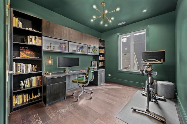 office space featuring visible vents, baseboards, wood finished floors, and an inviting chandelier