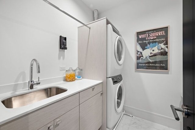 clothes washing area featuring a sink, marble finish floor, cabinet space, and stacked washer / dryer