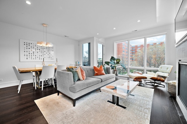 living area featuring baseboards, recessed lighting, and dark wood-type flooring