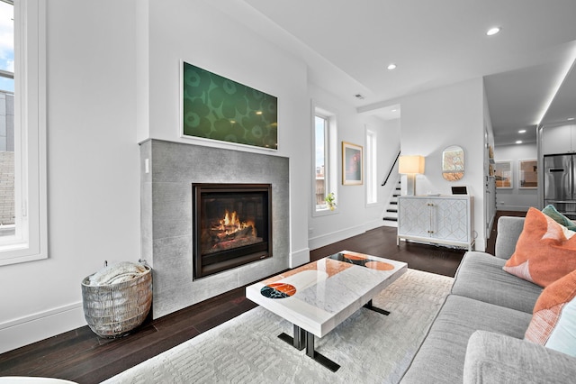 living room featuring recessed lighting, baseboards, a tiled fireplace, and wood finished floors