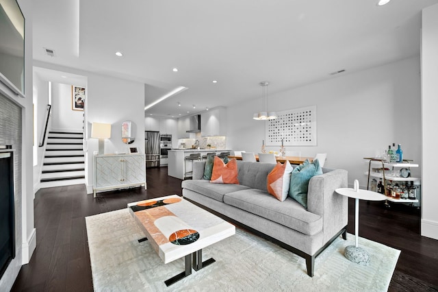 living room featuring recessed lighting, stairs, dark wood-style floors, and visible vents