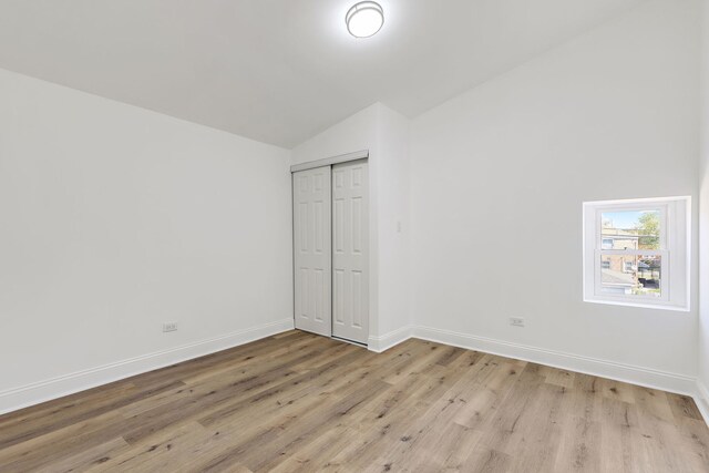 5068 W Congress Pkwy, Chicago, IL 60644 - unfurnished bedroom featuring vaulted ceiling, light wood-type flooring, baseboards, and a closet