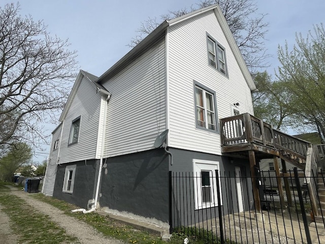 view of side of property featuring a gate, fence, and a deck
