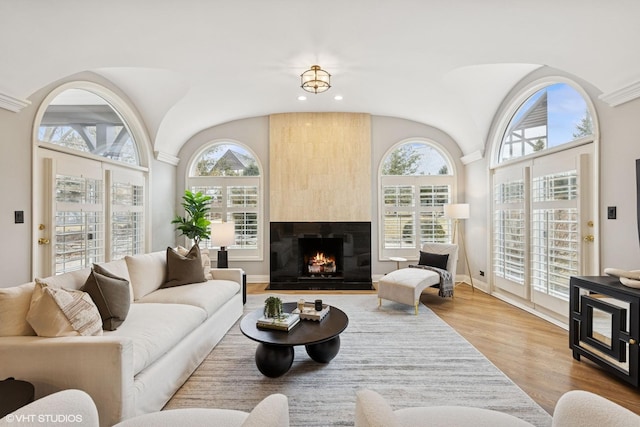 living room with recessed lighting, vaulted ceiling, wood finished floors, and a fireplace